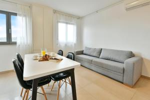 een woonkamer met een tafel en een bank bij Apart Residence Rudan 1 in Rovinj