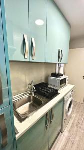 eine Küche mit einer Spüle und einer Mikrowelle in der Unterkunft Centro Madrid in Madrid