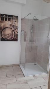 una doccia in bagno con una foto sulla parete di Gîte location meublée Aumale - studio en centre-ville - La maison en brique a Aumale