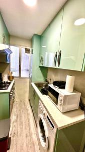 a kitchen with green cabinets and a washing machine at Centro Madrid in Madrid