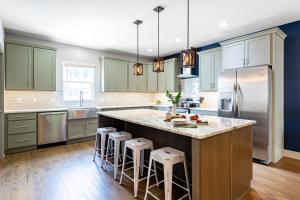 a kitchen with green cabinets and a large island with bar stools at Waverly by AvantStay Nashville-Inspired Townhome w Luxury Kitchen Pool Table in Nashville