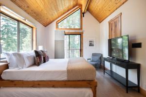 - une chambre avec un lit et une télévision à écran plat dans l'établissement Timberline by AvantStay Stunning Chalet Cabin w Hot Tub Pool Table Home Theater, à Tahoe Vista