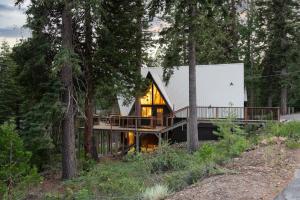 une maison dans les bois avec une grande terrasse dans l'établissement Timberline by AvantStay Stunning Chalet Cabin w Hot Tub Pool Table Home Theater, à Tahoe Vista