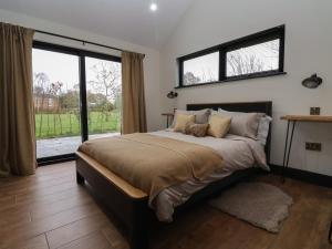 a bedroom with a large bed and a large window at Blackcap in Huggate