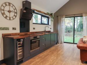 a kitchen with gray cabinets and a large clock on the wall at Blackcap in Huggate