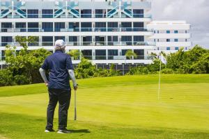 een man staat op een golfbaan bij Apartment with private jacuzzi and King bed Near Hard Rock hotel & casino in Punta Cana