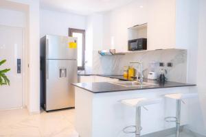 een witte keuken met een roestvrijstalen koelkast bij Apartment with private jacuzzi and King bed Near Hard Rock hotel & casino in Punta Cana