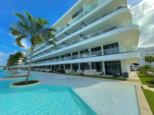 een groot gebouw met een zwembad ervoor bij Apartment with private jacuzzi and King bed Near Hard Rock hotel & casino in Punta Cana