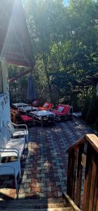 a patio with chairs and umbrellas on a brick patio at Casa langa rau in Bran