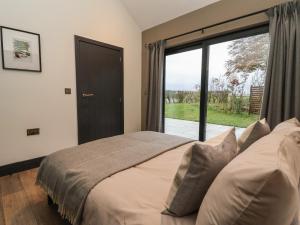 a bedroom with a bed and a large window at Wren in Huggate