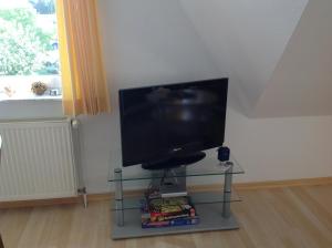 a television sitting on a glass table in a room at Fewo Zur Ilmenau in Melbeck