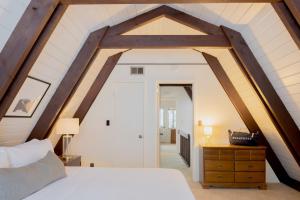 an attic bedroom with a white bed and a wooden ceiling at Tahoe Bliss by AvantStay Mins from SlopesShore in Olympic Valley