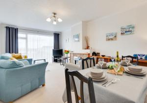 a dining room and living room with a table and a couch at Primley Park in Paignton