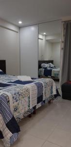 1 dormitorio con 2 camas y espejo en Departamento Altos de la Merced en Salta