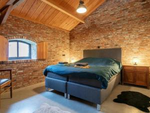 um quarto com uma cama numa parede de tijolos em De Hoeve I em Hulsel