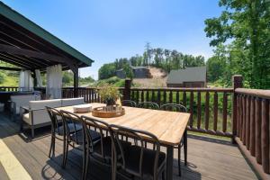 um deque de madeira com uma mesa e cadeiras de madeira em Tennessee Blue by AvantStayHeart of Pigeon Forge em Pigeon Forge