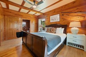 a bedroom with a bed in a room with wooden walls at Tennessee Blue by AvantStayHeart of Pigeon Forge in Pigeon Forge