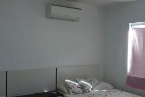 a white room with a bed and a window at Casa de campo com piscina in Palhoça