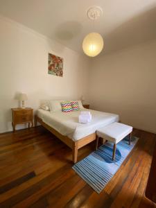 een slaapkamer met een bed, een bank en een lamp bij Castelletto Bed & Breakfast in Santiago