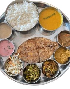 una bandeja de comida con diferentes tipos de comida. en KonkanParadise,Hotel Malvan Beach, en Malvan