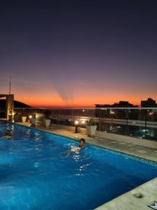 a person swimming in a swimming pool at night at El Samario Cumbia Host-Playa Salguero- Santa Marta in Gaira
