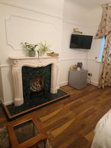 a living room with a fireplace and a television at 51 Nonsuch Walk, Cheam in Cheam