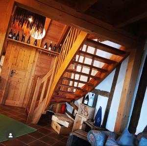 an attic room with a wooden staircase and a door at Klein Kattult in Windeck