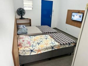a small bedroom with a bed with a blue door at Studio proximo Expo Center Norte bairro Vila Guilherme São Paulo in São Paulo