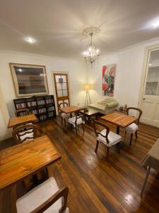 una sala de estar con mesas y sillas de madera. en Castelletto Bed & Breakfast, en Santiago