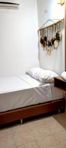 Una cama en una habitación con zapatos colgando en la pared en HOTEL BOHO BOUTIQUE en Quibdó