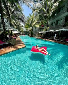 a woman laying in a float in a swimming pool at Diamond Resort in Phuket Town