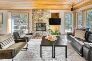 ein Wohnzimmer mit Ledermöbeln und einem Steinkamin in der Unterkunft Tanner by AvantStay Modern Cascades Escape in Brothers