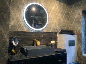 a bathroom with a sink and a mirror at Midcoast Wohnung „THE BLACK“ in Nortorf