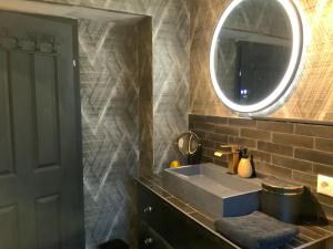 a bathroom with a sink and a mirror at Midcoast Wohnung „THE BLACK“ in Nortorf
