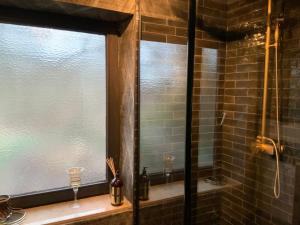 baño con ventana y 2 vasos en una encimera en Midcoast Wohnung „THE BLACK“, en Nortorf