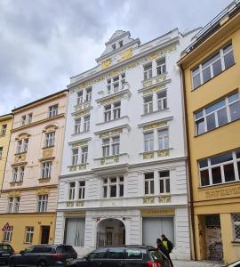 een wit gebouw met een klok erop bij Small apartment for groups in city centre in Praag
