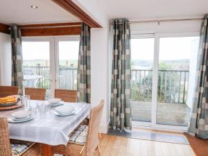 a dining room with a table and views of the ocean at Firm Anchor in Salcombe