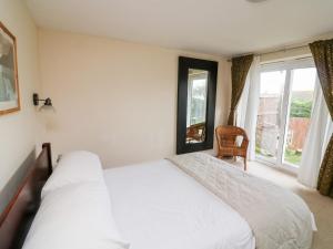 a bedroom with a white bed and a window at Firm Anchor in Salcombe