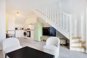 a living room with a table and chairs and a staircase at La Résidence Alpha Viroflay 301 - Duplex 2 chambres - 6 pers in Viroflay +7 photos