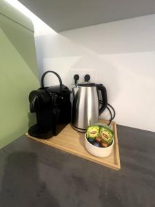 a tea kettle and a bowl of food on a wooden shelf at La Résidence Alpha Viroflay 301 - Duplex 2 chambres - 6 pers in Viroflay