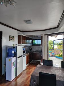 una cocina con electrodomésticos blancos y una mesa con sillas. en 2BD, 2BR condo Penthouse, en Davao City