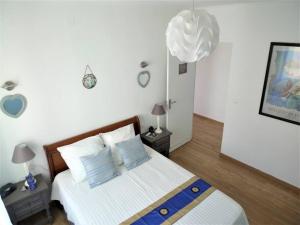 RiaにあるMaison 4 pers avec jardin au pied des montagnesの青と白の枕が付いたベッドのある寝室