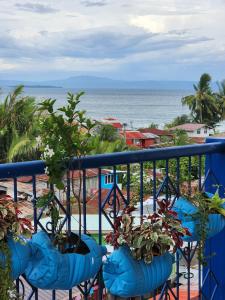 un balcón con macetas y vistas al océano. en 2BD, 2BR condo Penthouse, en Davao City