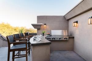 um pátio com uma mesa, cadeiras e um fogão em Julep by AvantStay Stylish 9 BR Estate w Mid-Century Modern Decor em Phoenix