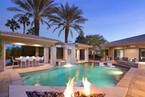 uma piscina com fogueira e uma casa em Casa Palmera by AvantStay Entertainers Oasis w Guesthouse Minutes from Coachella Valley em Bermuda Dunes