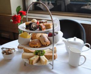 a three tiered tray of bread and pastries on a table at Healey House Hotel in Batley