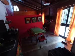 a dining room with a green table and chairs at Titernig del Monte in Capilla del Monte