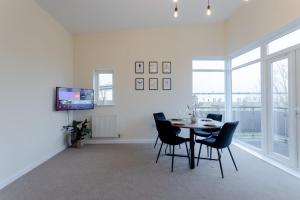 a dining room with a table and chairs and a tv at Premium Nights - Harry Potter, Professional, Family stay in Watford