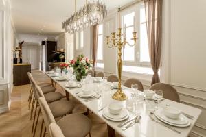 una sala da pranzo con un lungo tavolo e sedie di Luxury 7 bedrooms & 5 Bathrooms Monument View Terrace -Champs Elysées a Parigi
