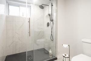 W łazience znajduje się prysznic ze szklanymi drzwiami. w obiekcie Contemporary renovated house in southshore MTL w mieście Brossard